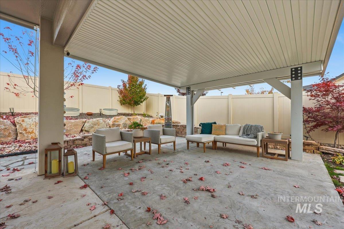 Fenced backyard featuring a patio and an outdoor hangout area