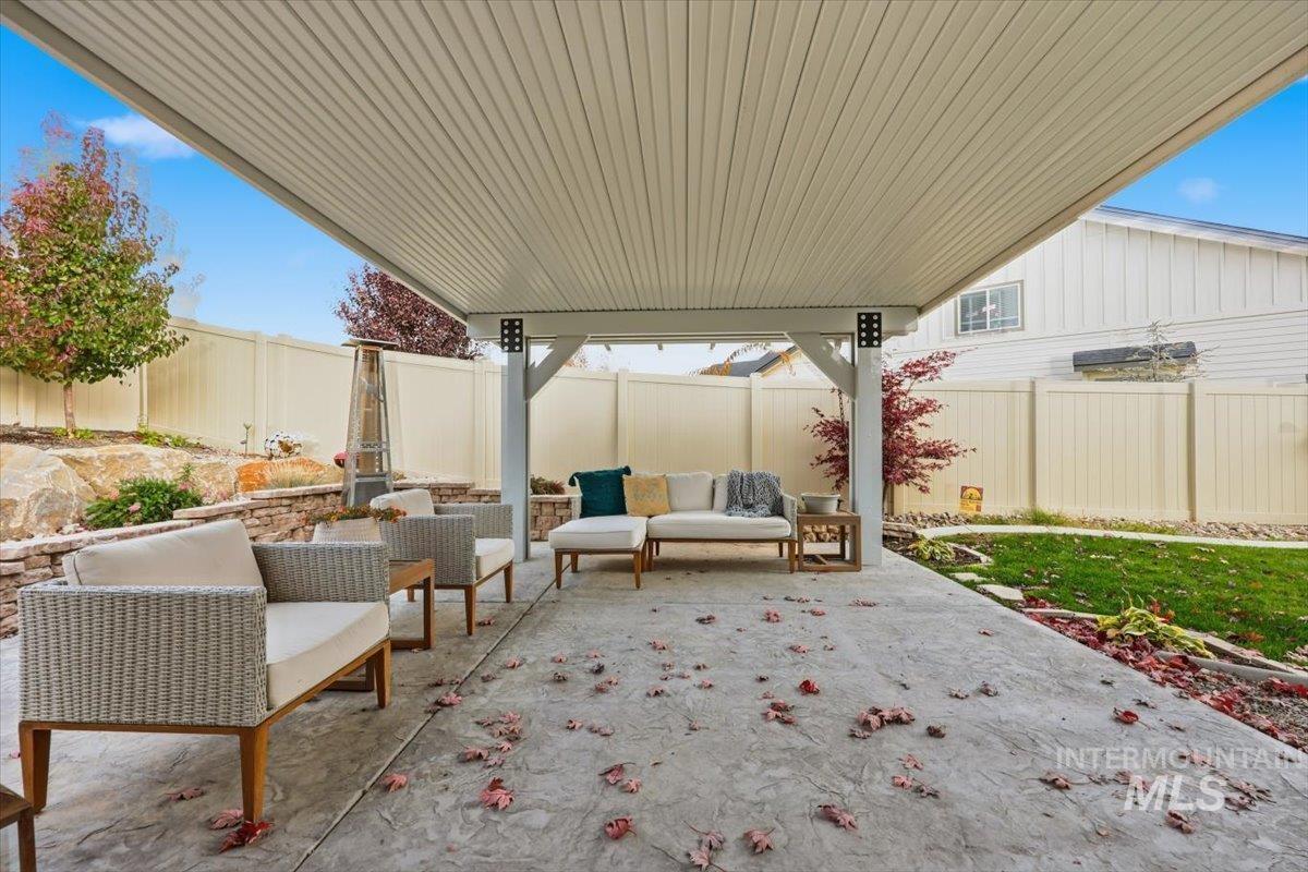 Fenced backyard with outdoor lounge area and a patio