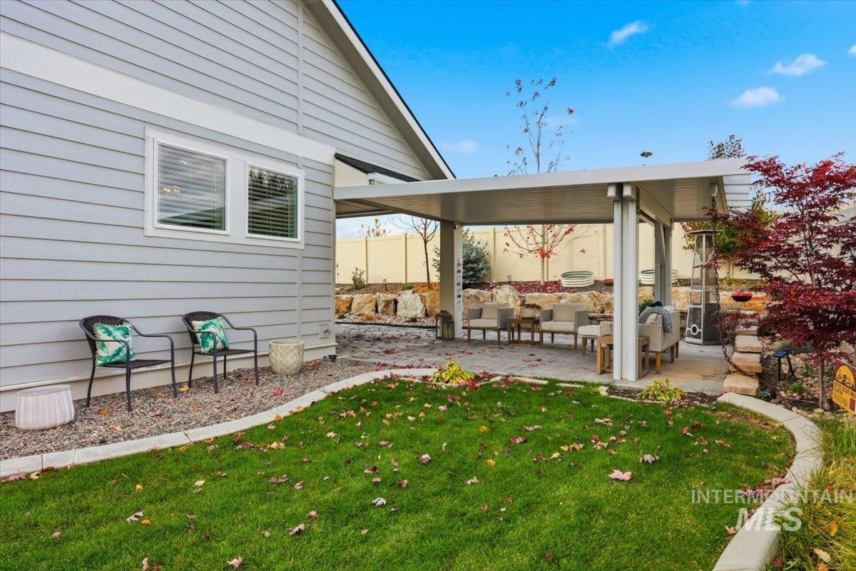View of green lawn with a patio and outdoor lounge area