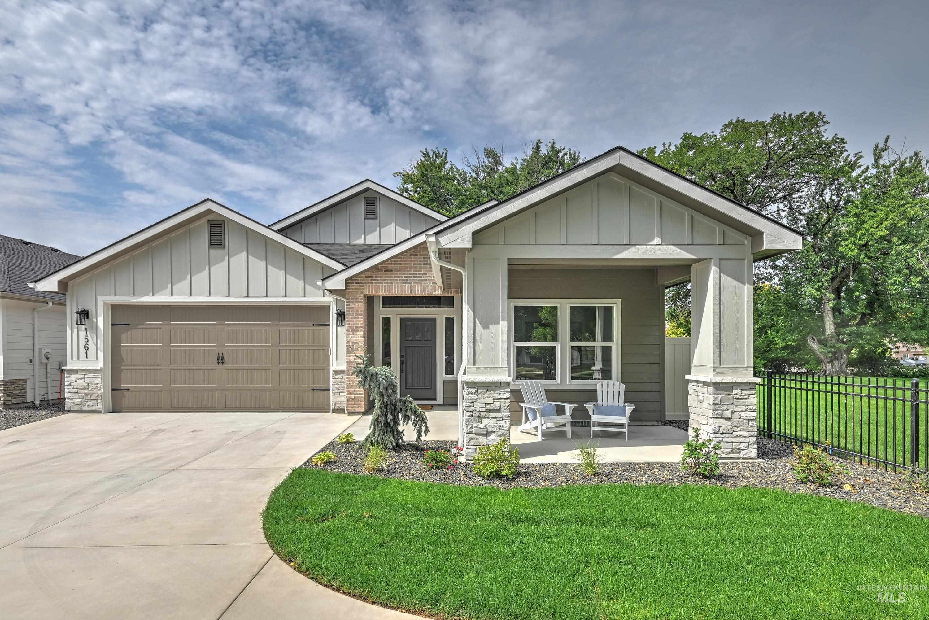 Craftsman-style home with a porch, board and batten siding, stone & brick accents, and concrete driveway