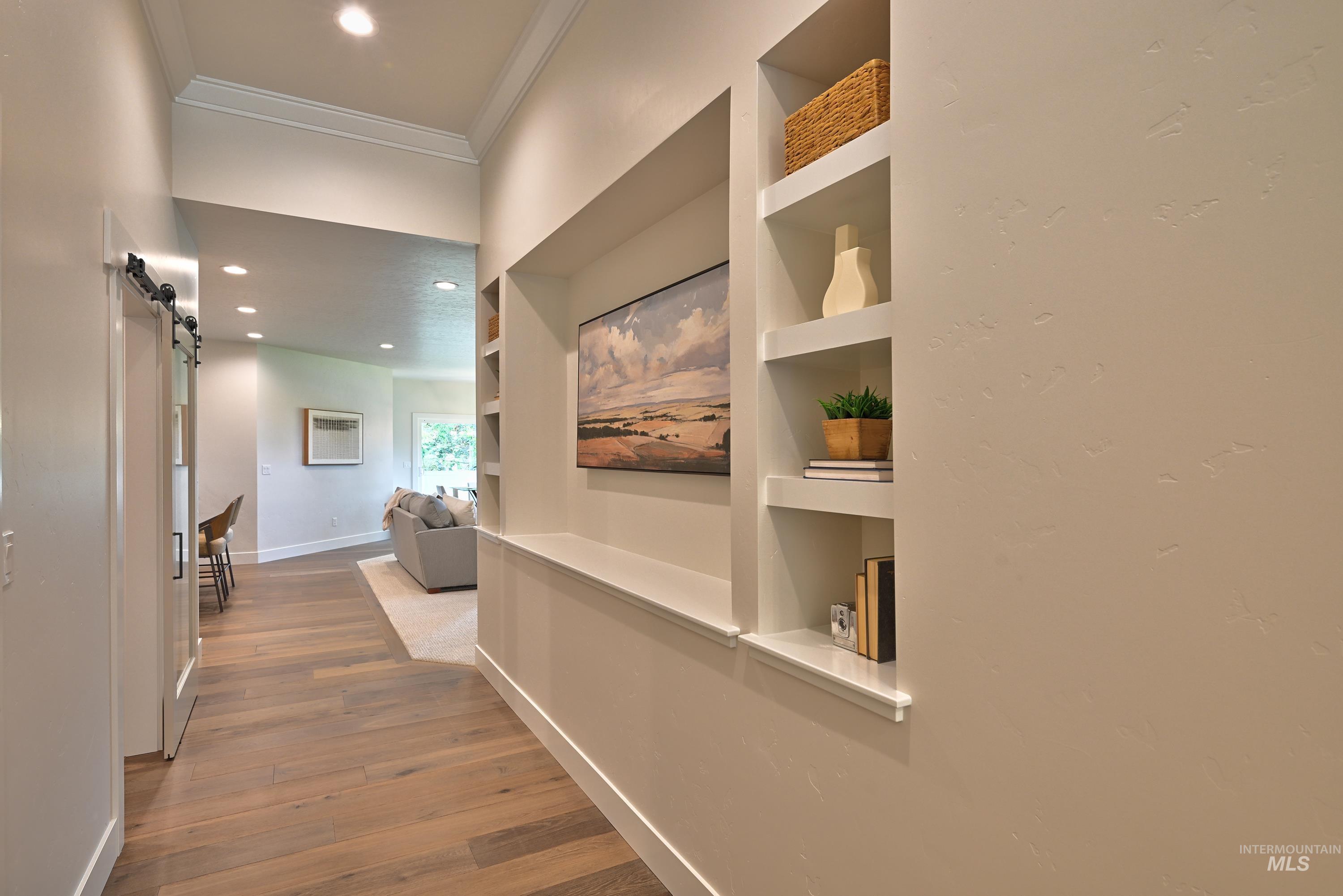 Corridor featuring ornamental molding, recessed lighting, wood finished floors