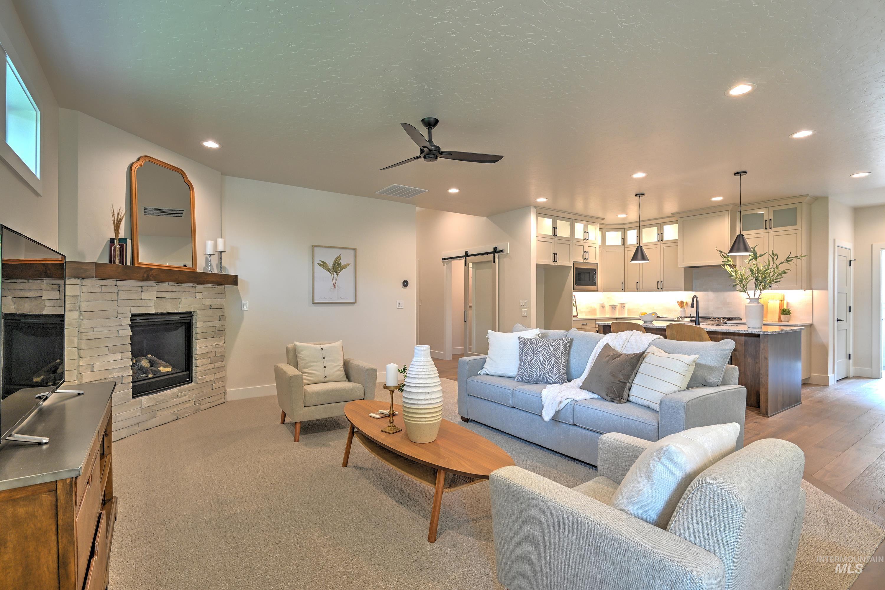Living area featuring ceiling fan, a fireplace, recessed lighting, and ample amount of natural light