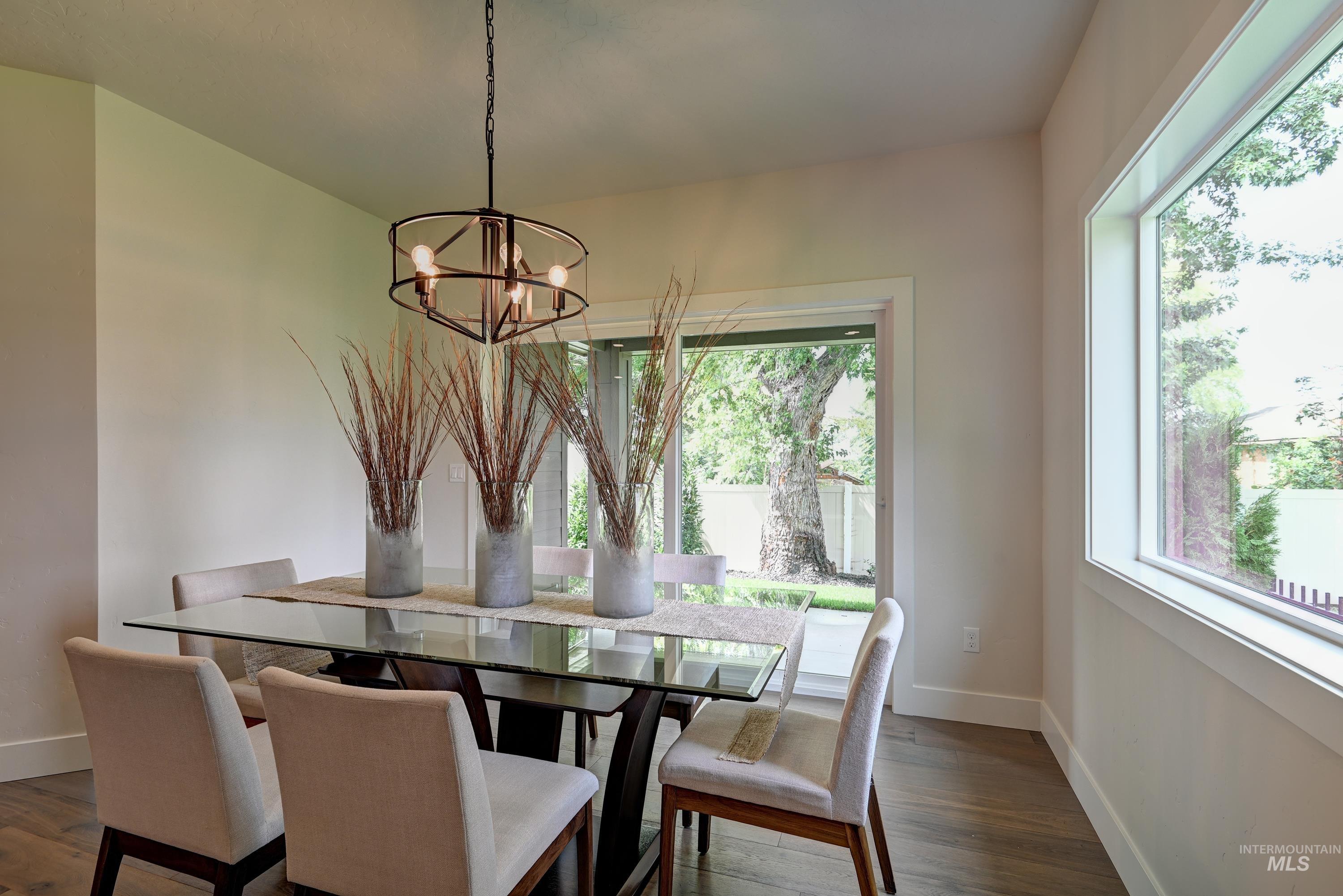 Dining room featuring picture window providing ample amount of natural light, light wood-type flooring, and a chandelier
