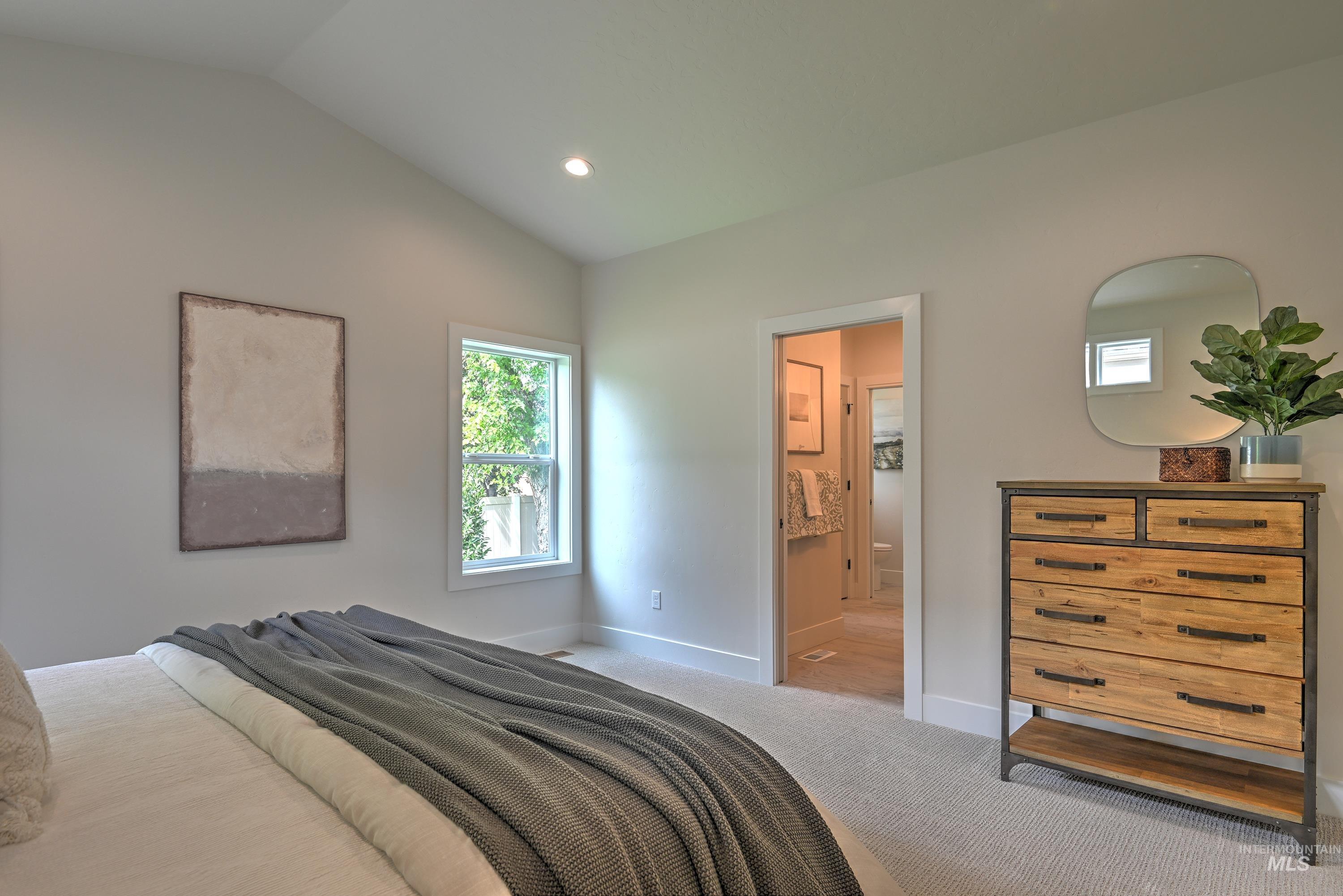 Bedroom featuring vaulted ceiling, carpet flooring, recessed lighting, and ensuite bath