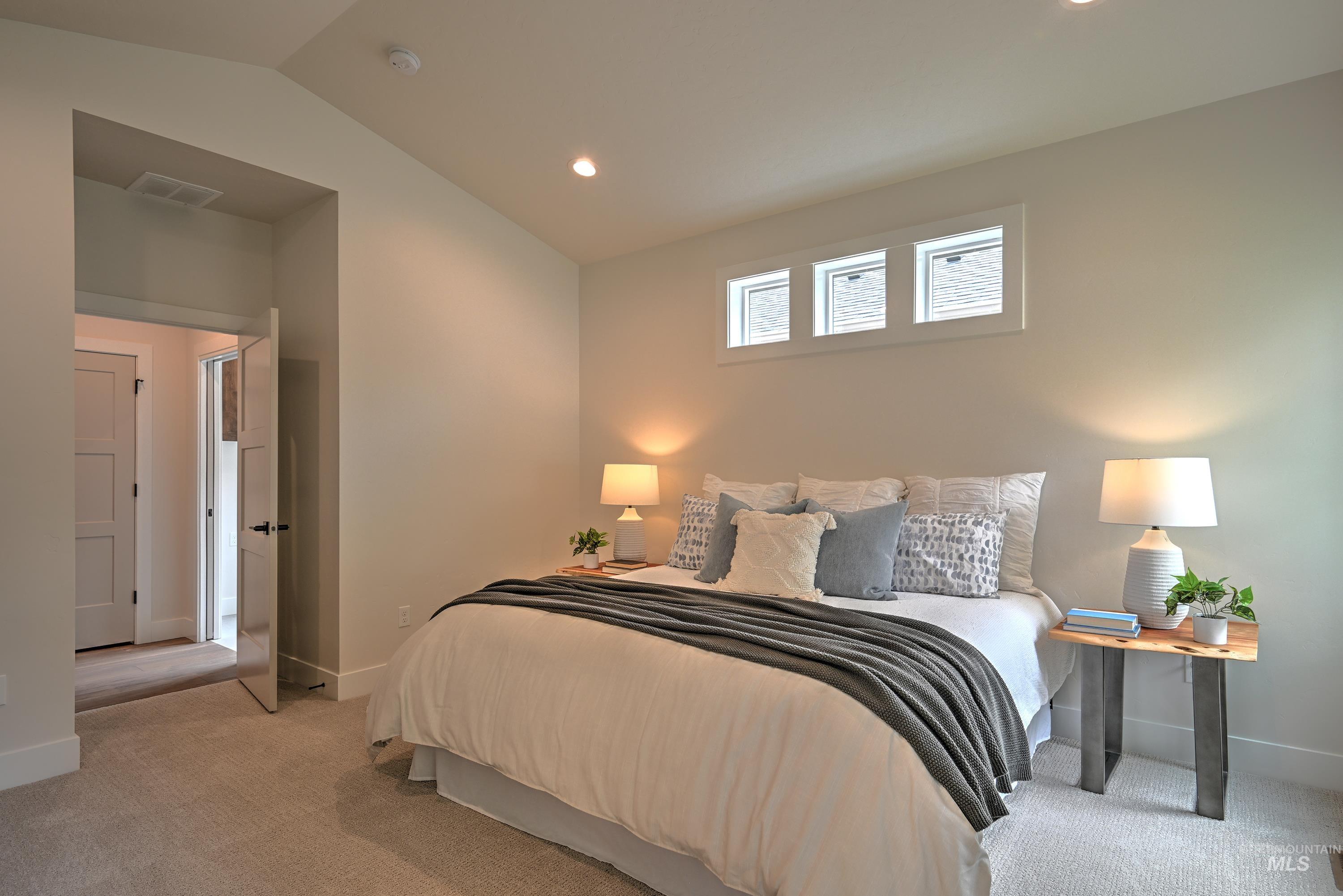 Carpeted Primary bedroom with recessed lighting, fan and vaulted ceiling