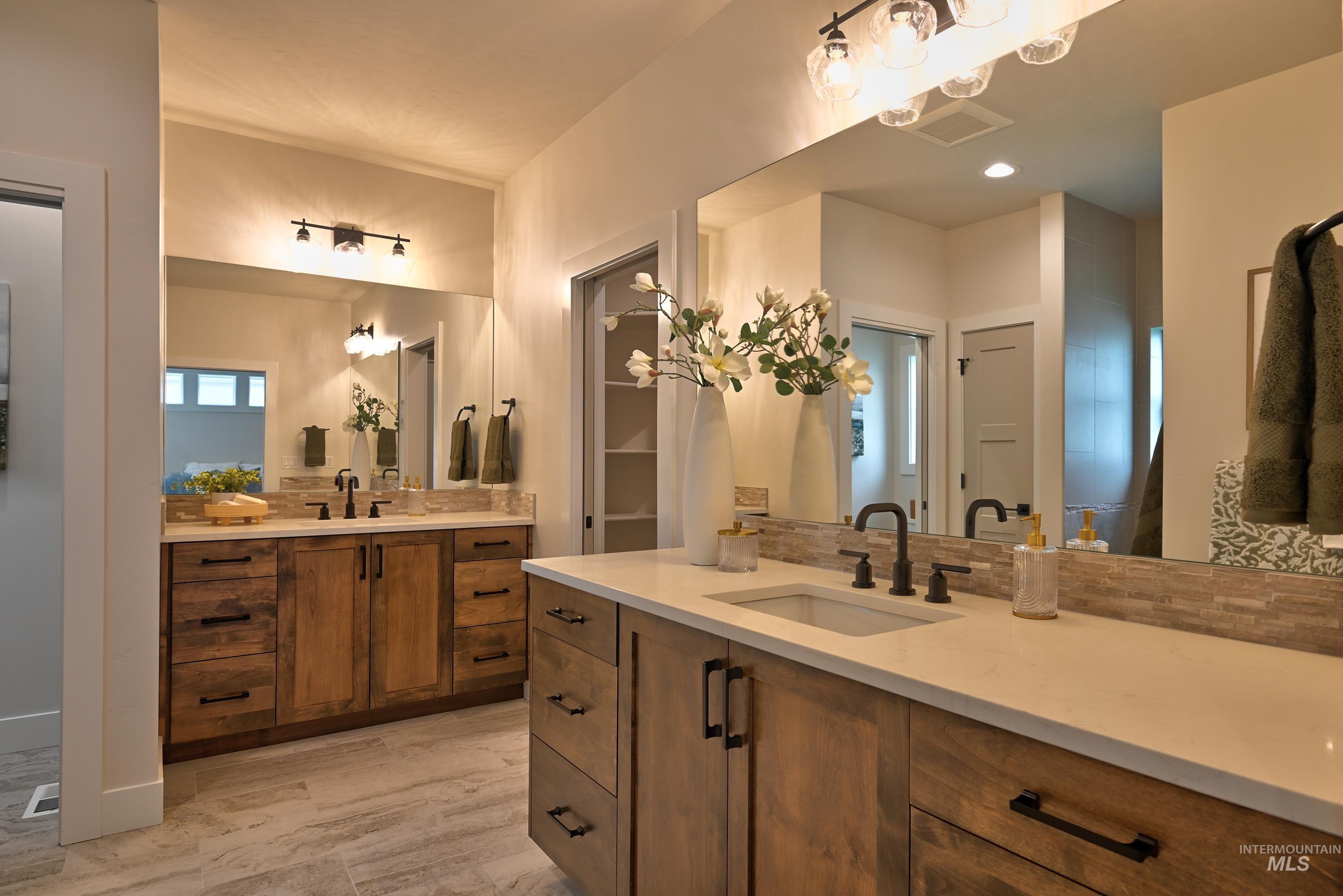 Bathroom featuring two vanities and tile flooring