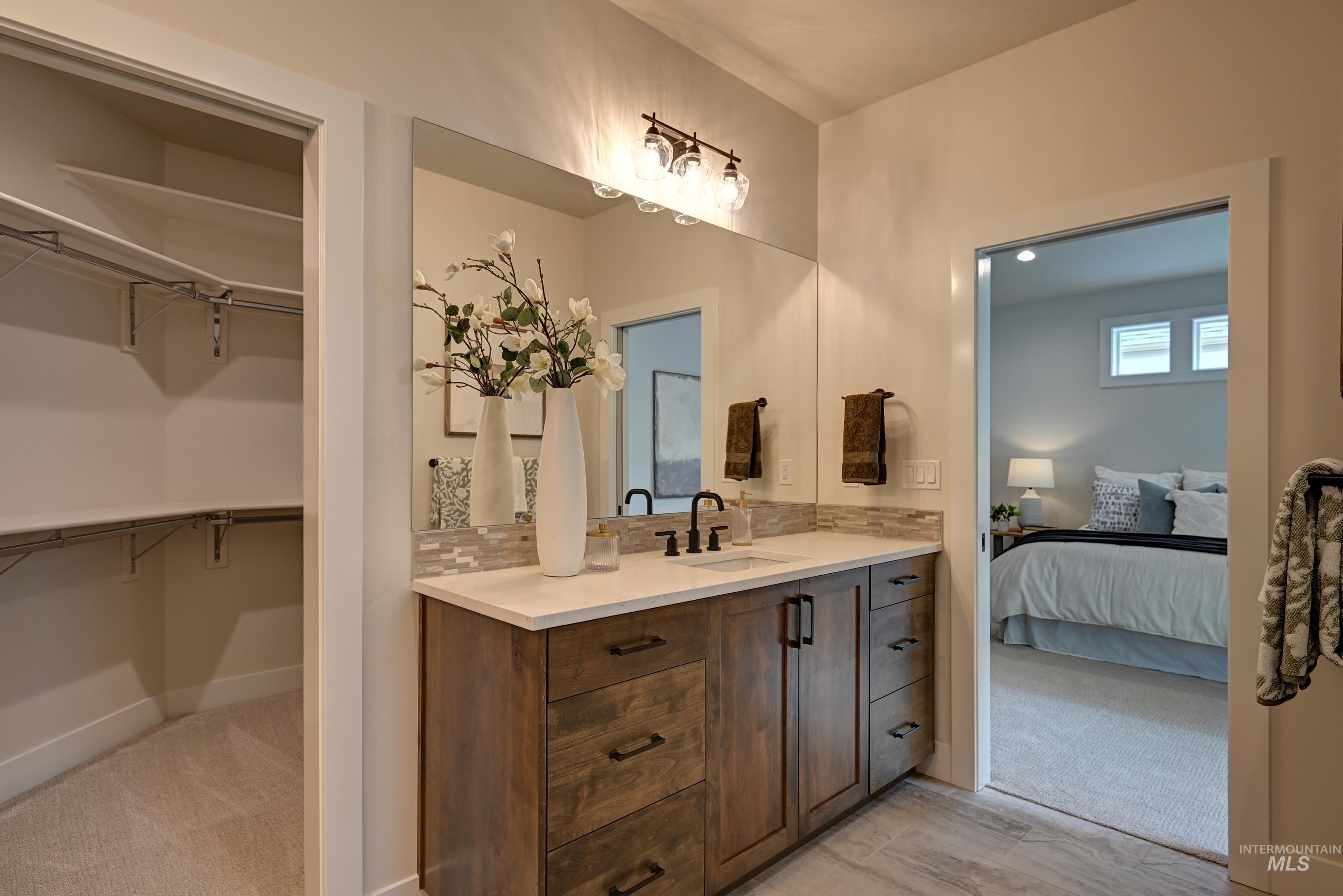 Ensuite bathroom with vanity and a walk in closet