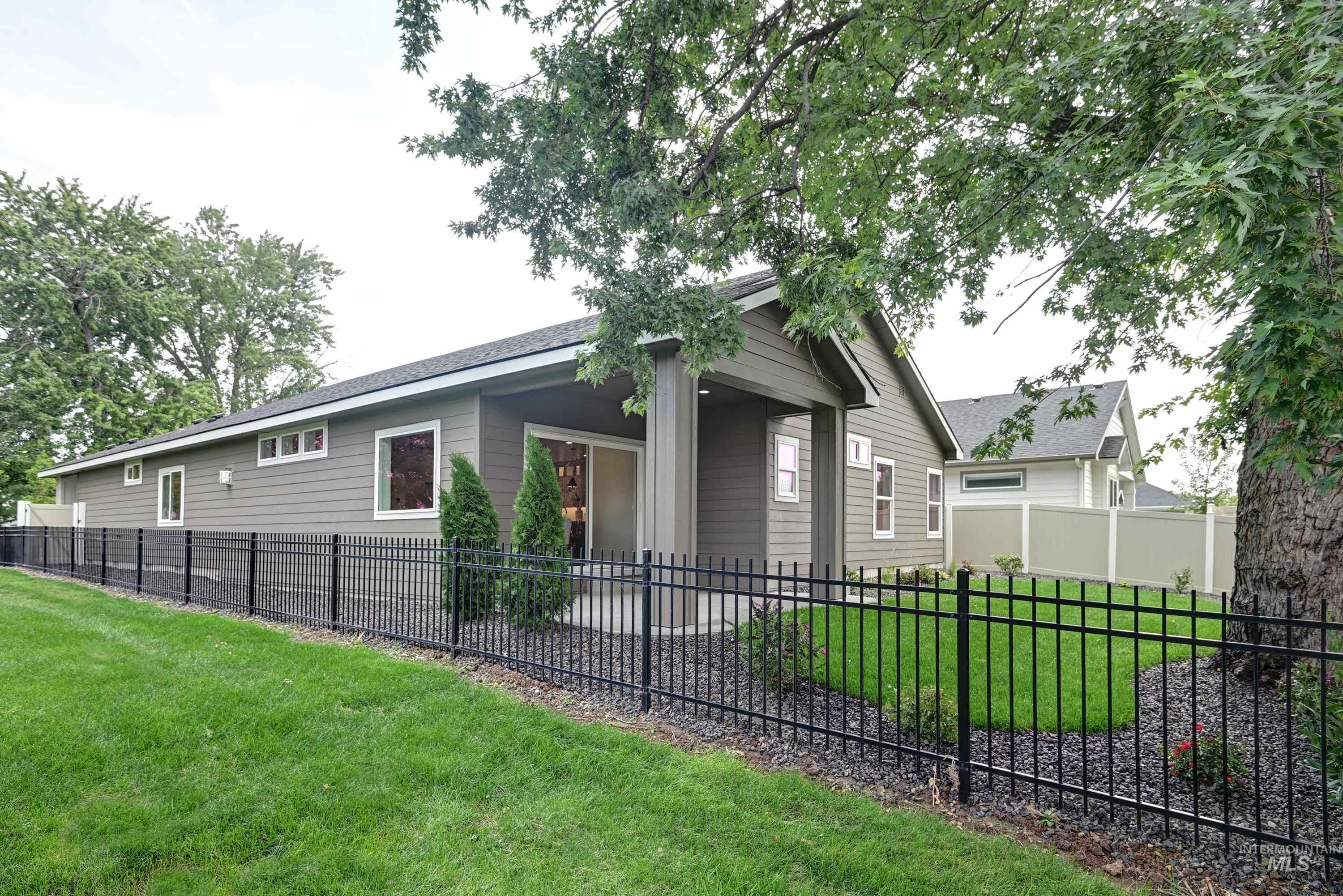 View of home's exterior with a fenced front yard and a shingled roof