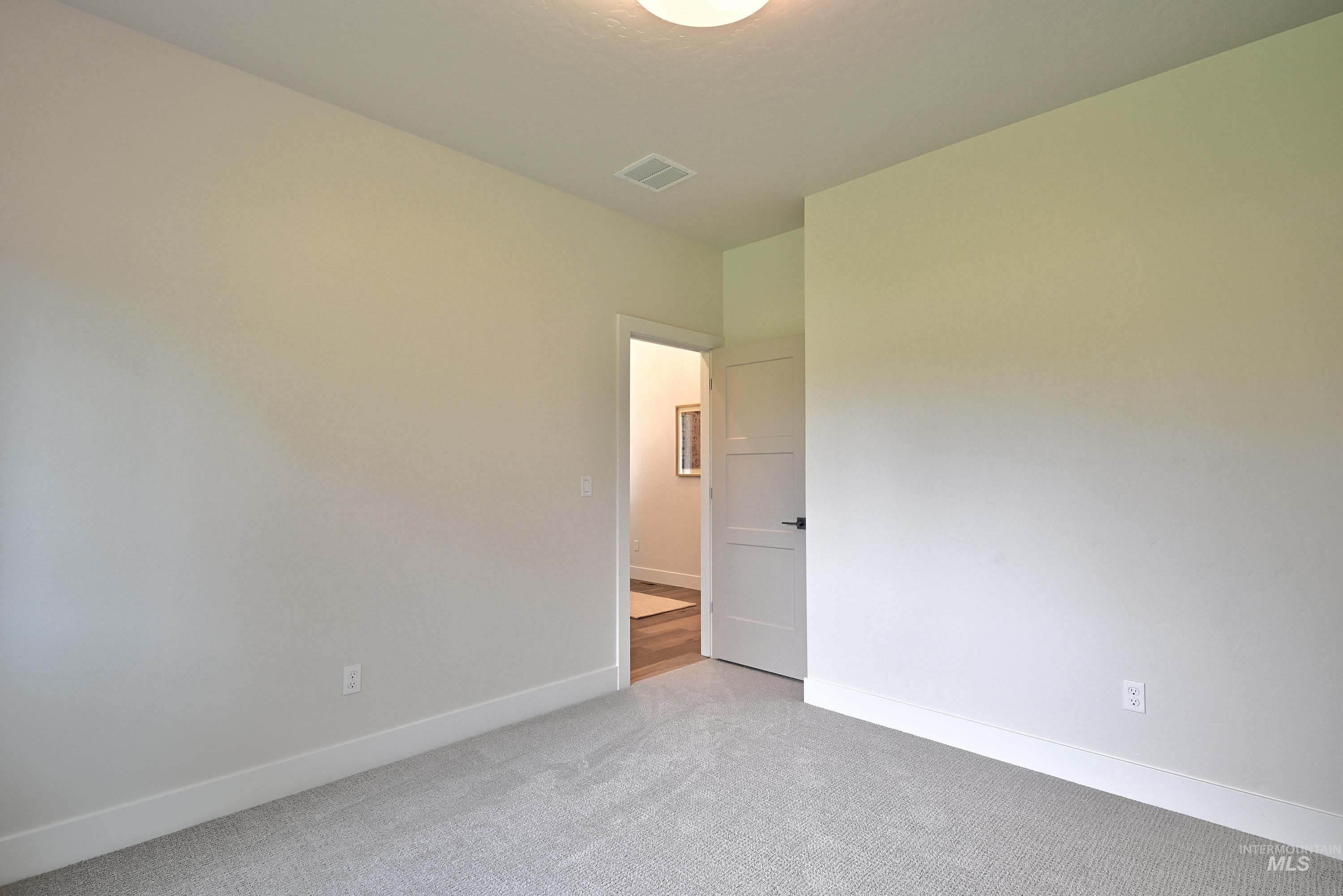 Carpeted empty bedroom featuring baseboards