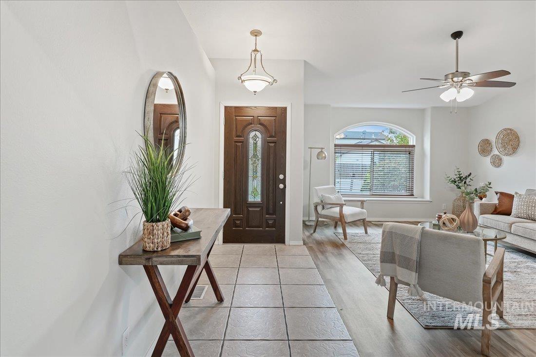 Foyer entrance with ceiling fan and light wood-style flooring