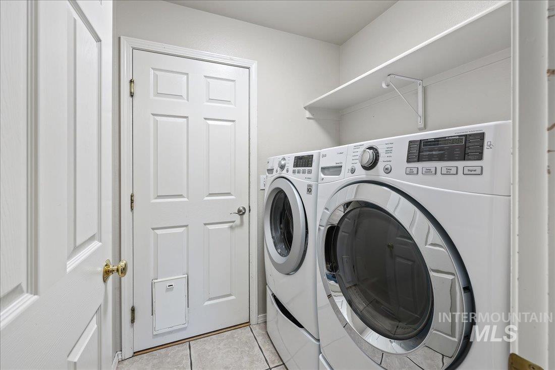 Washroom with light tile patterned floors and independent washer and dryer