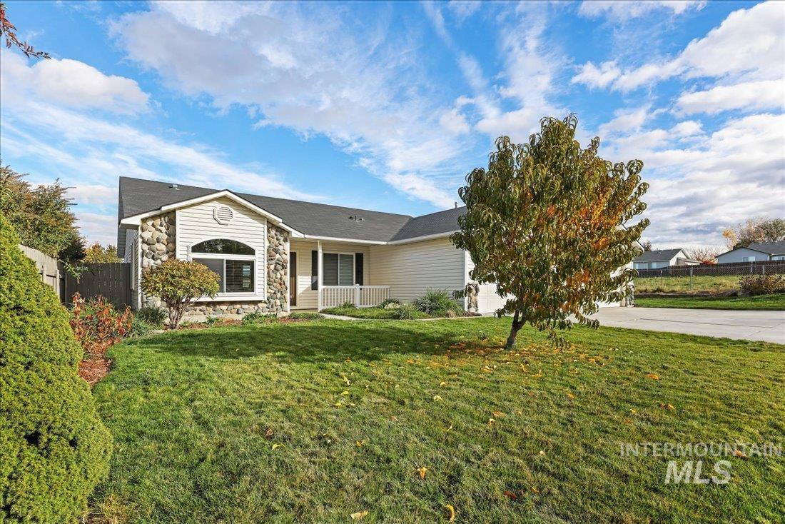 Ranch-style house with a porch, driveway, and stone siding