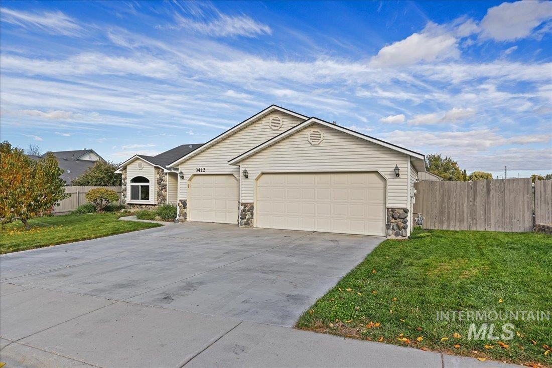 Ranch-style home with stone siding, concrete driveway, and an attached garage