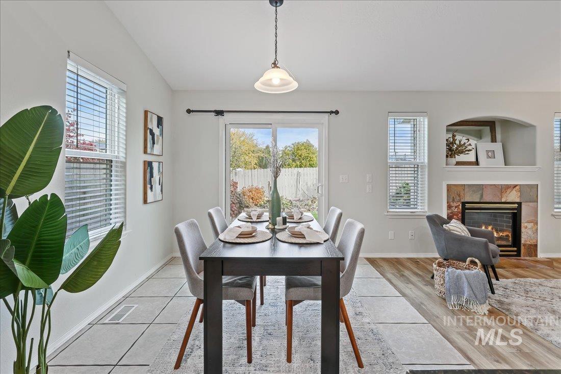Dining room with plenty of natural light, a premium fireplace, and light wood-style flooring