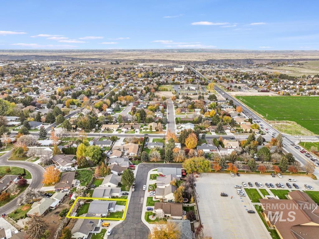 Aerial view of property and surrounding area with nearby suburban area
