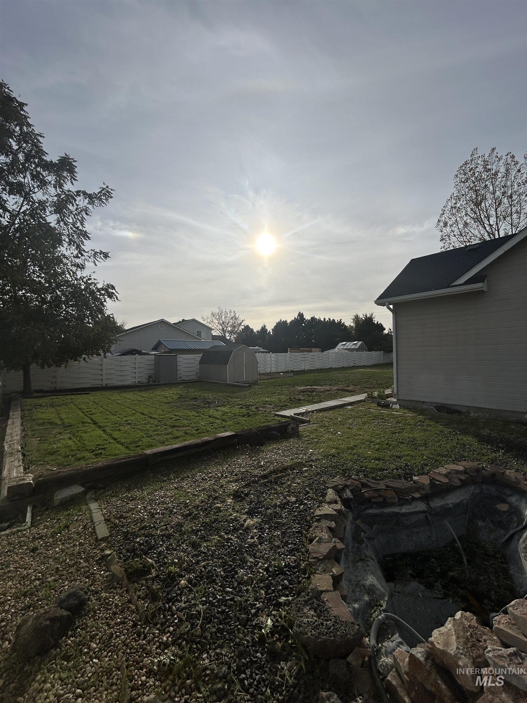 Fenced backyard featuring an outbuilding
