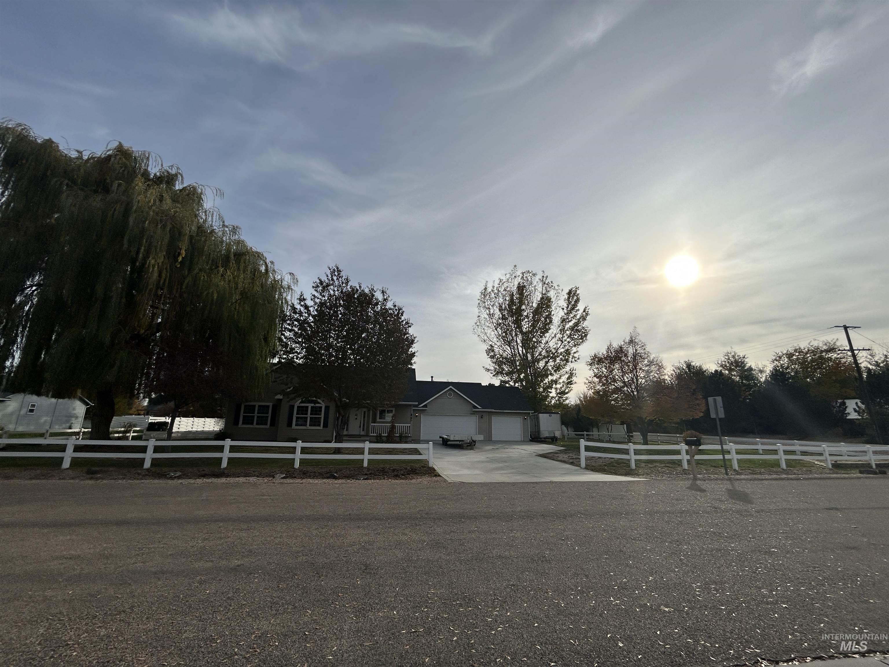 View of front of home with a fenced front yard, driveway, and a garage