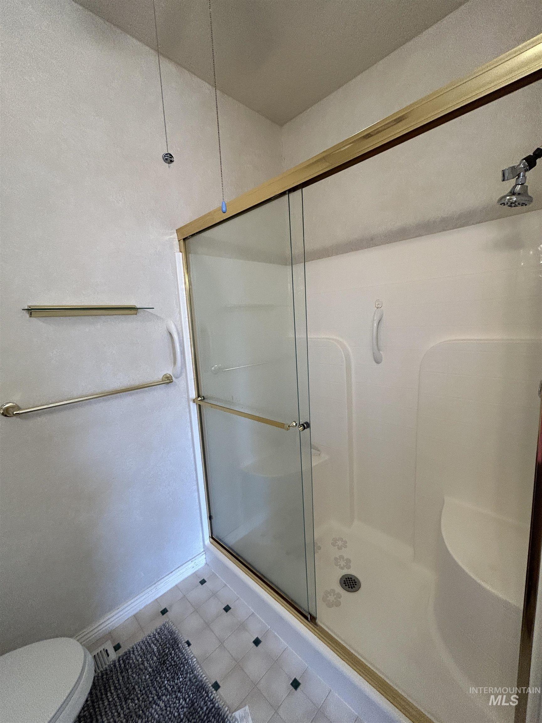 Bathroom featuring a shower stall and toilet
