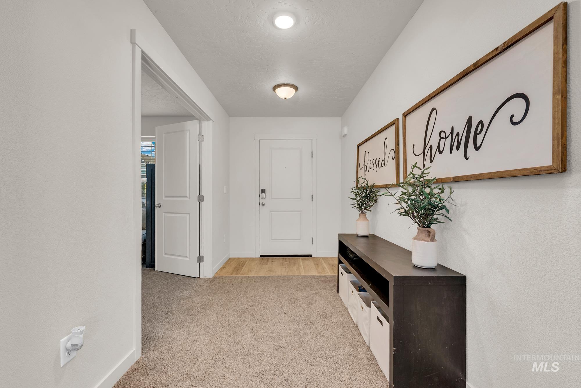 Entrance foyer with light colored carpet and a textured ceiling