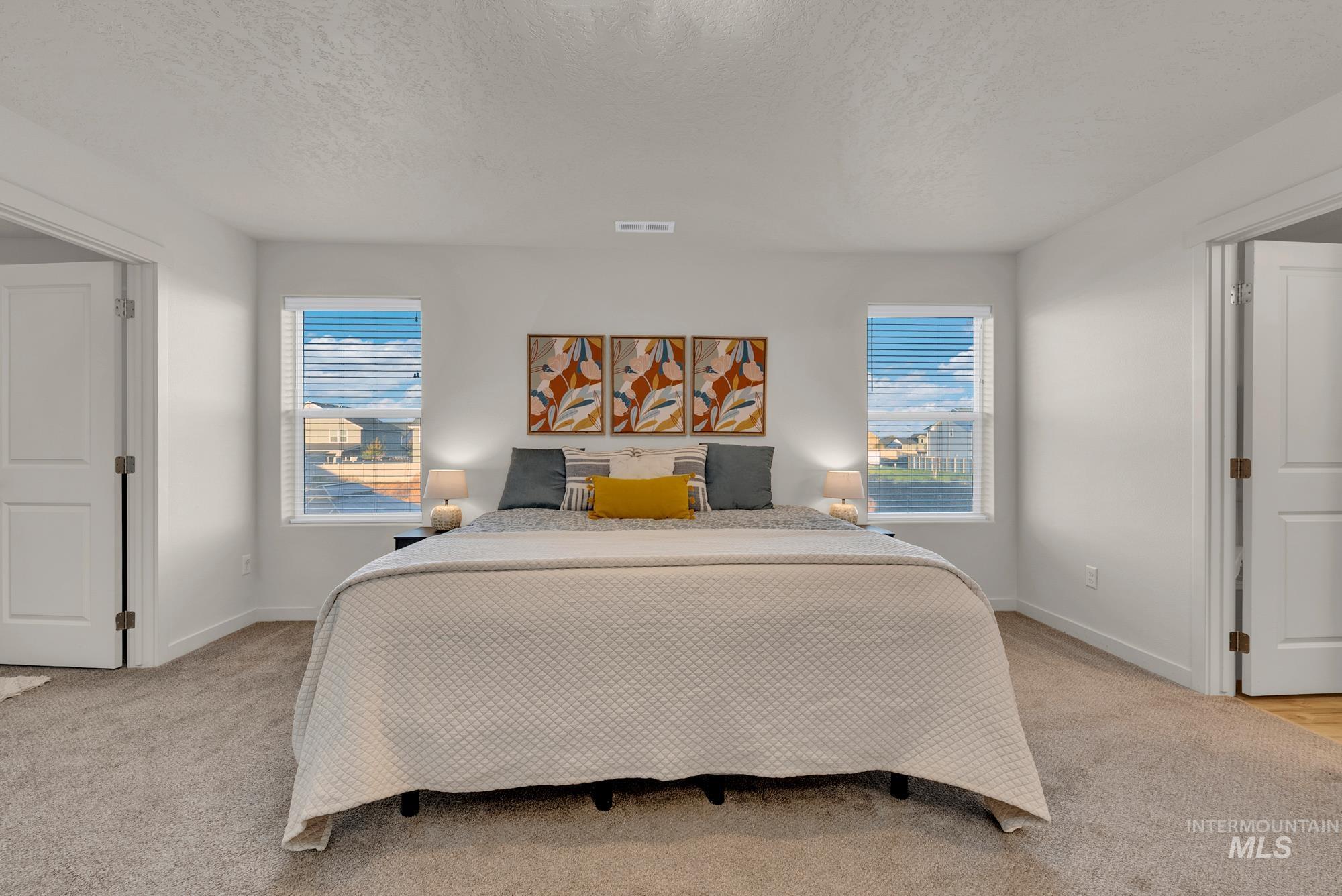 Bedroom featuring a textured ceiling and light colored carpet
