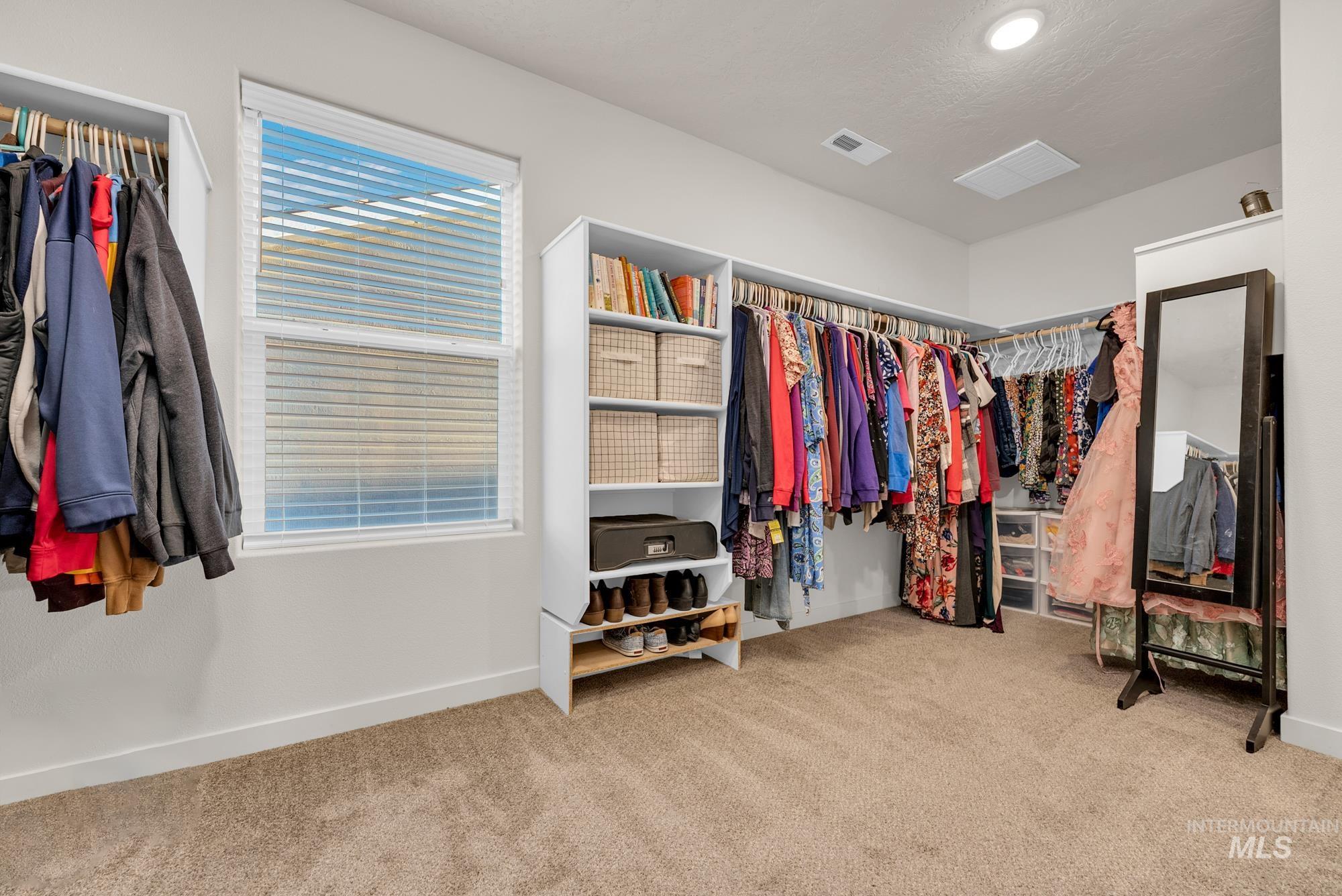 Walk in closet featuring light colored carpet