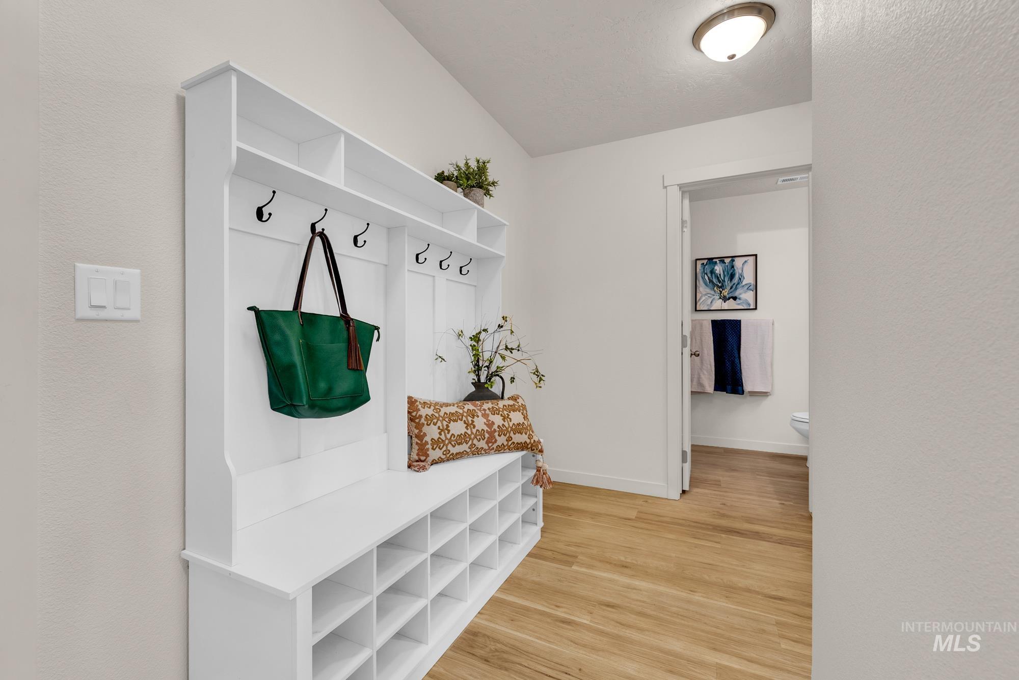 Mudroom with light wood-style flooring and a textured wall