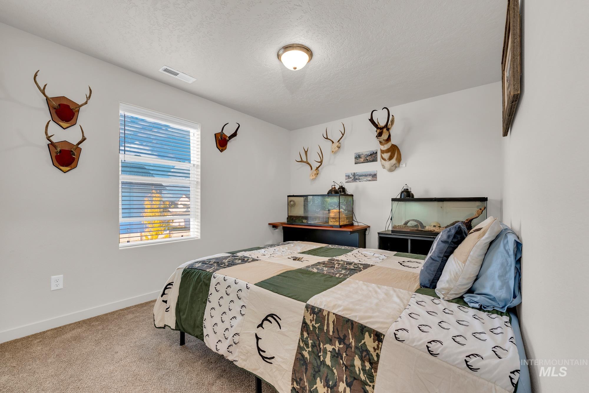 Carpeted bedroom with a textured ceiling and baseboards