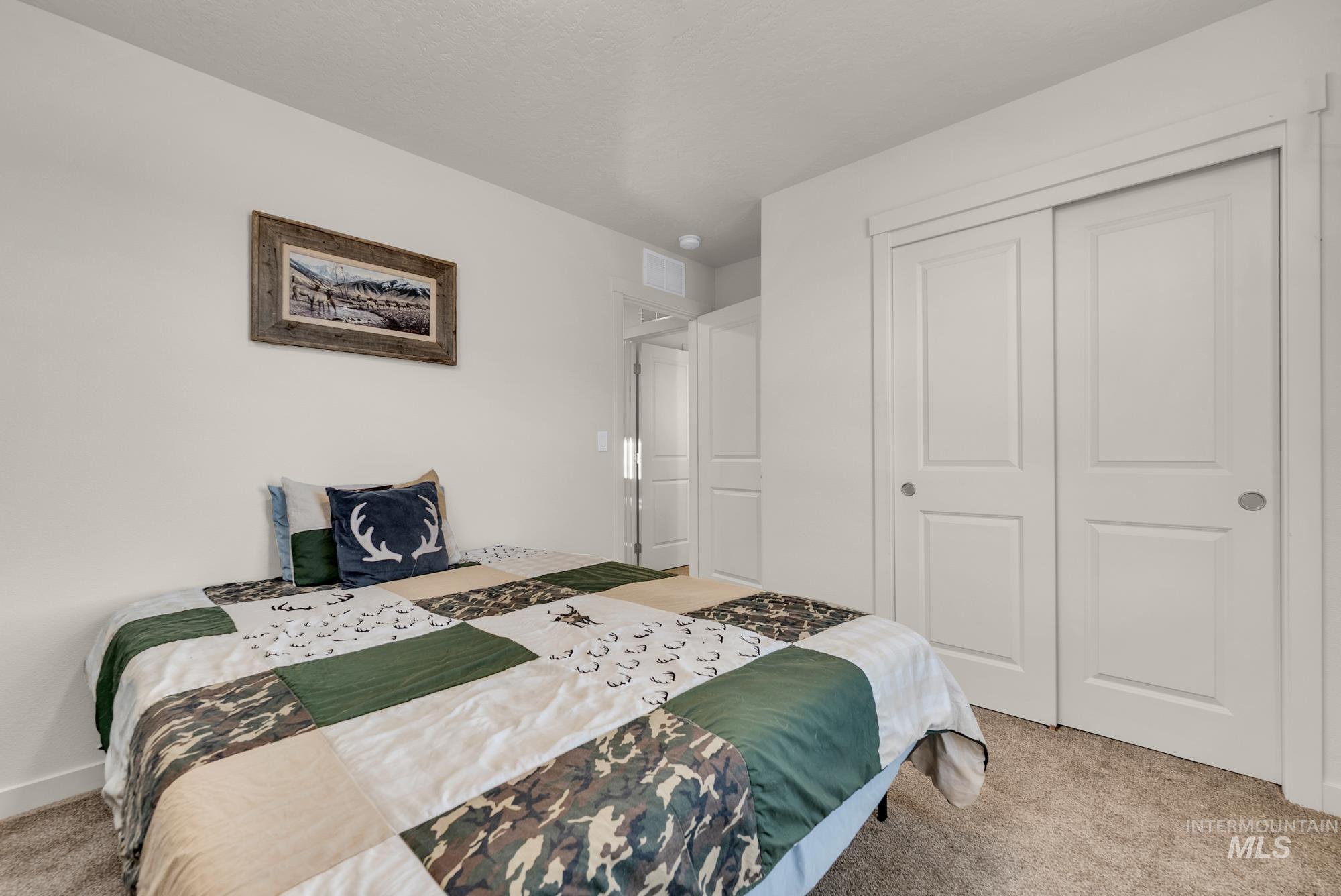 Bedroom featuring carpet and a closet