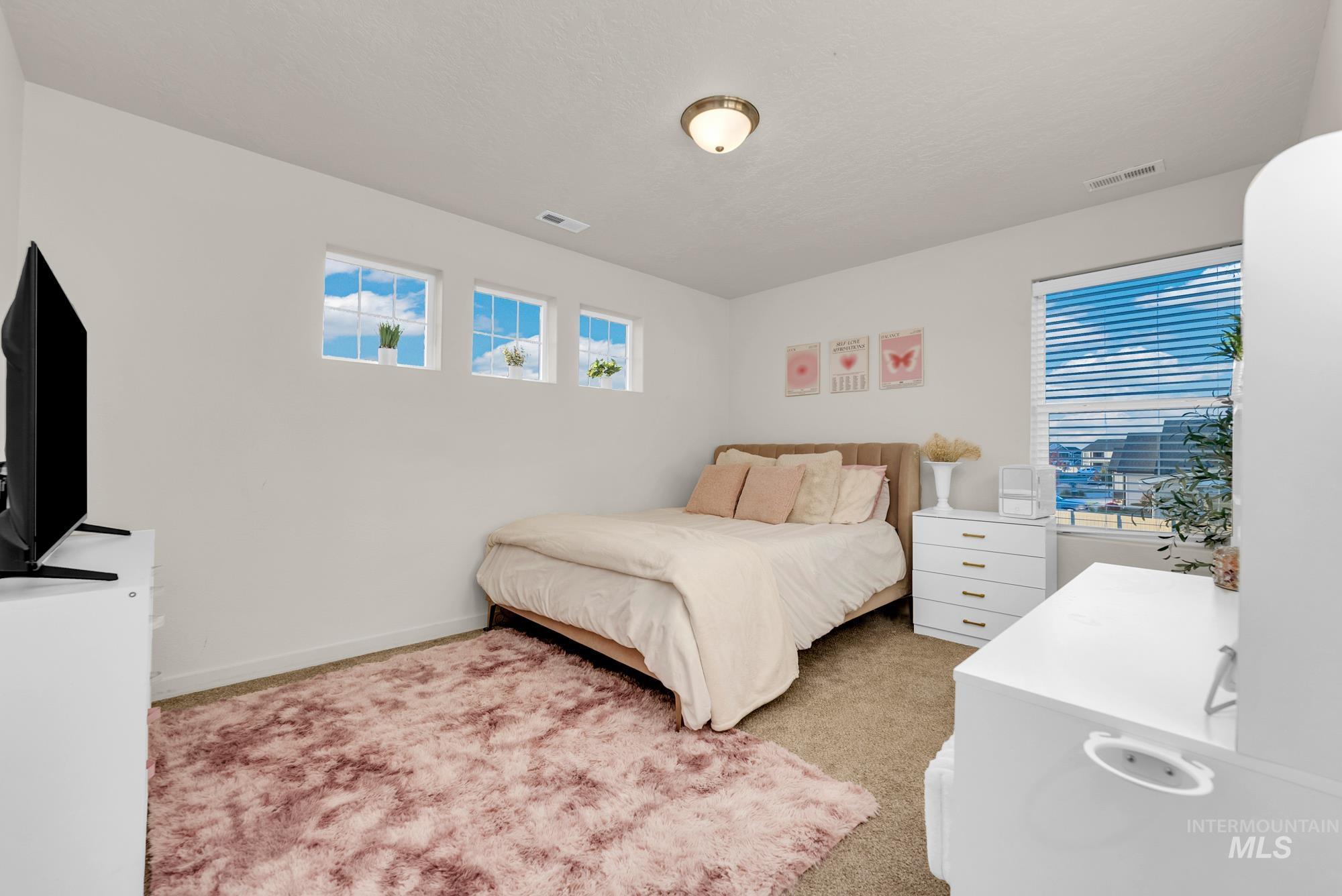 Bedroom with light colored carpet and baseboards