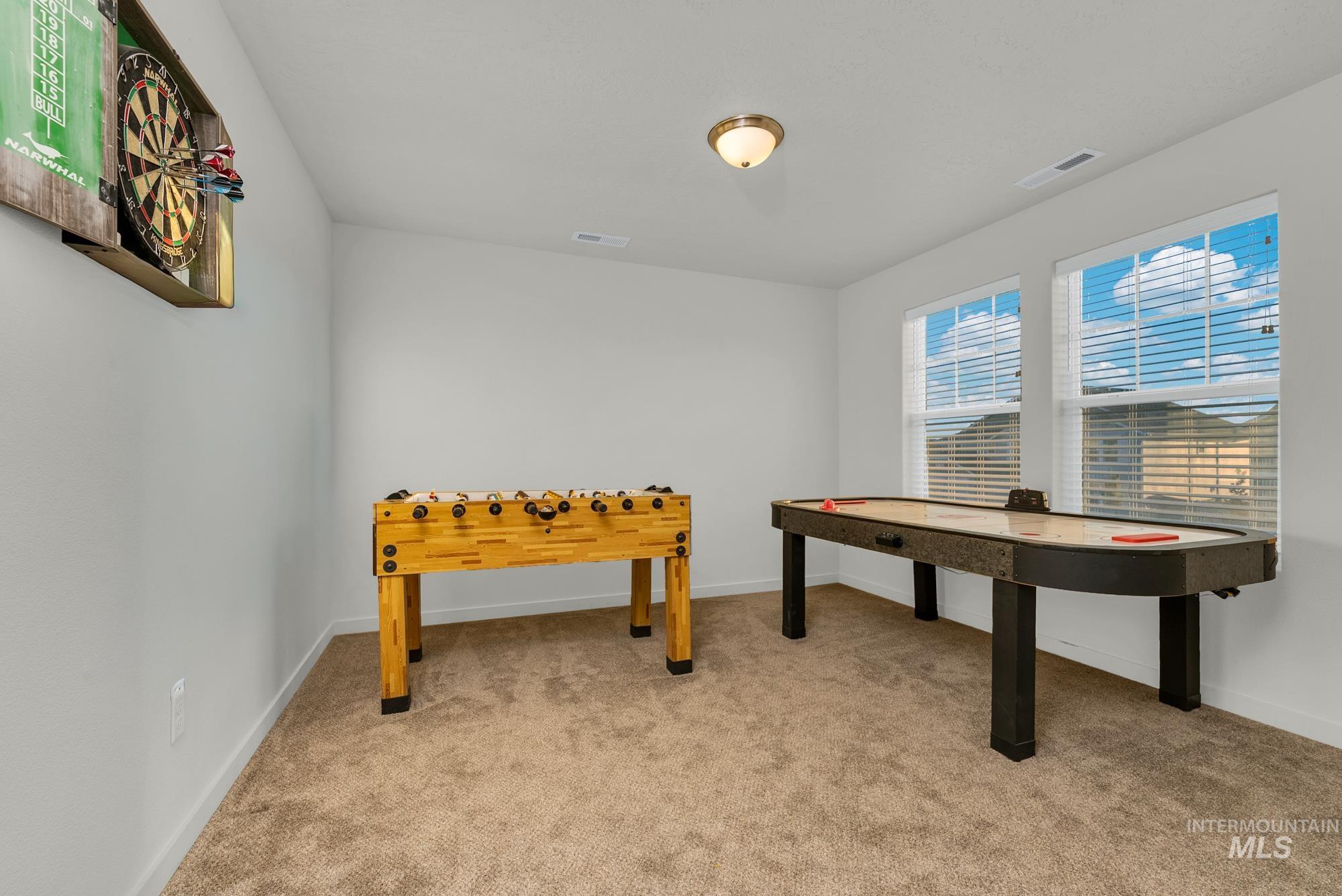Recreation room with light carpet and baseboards