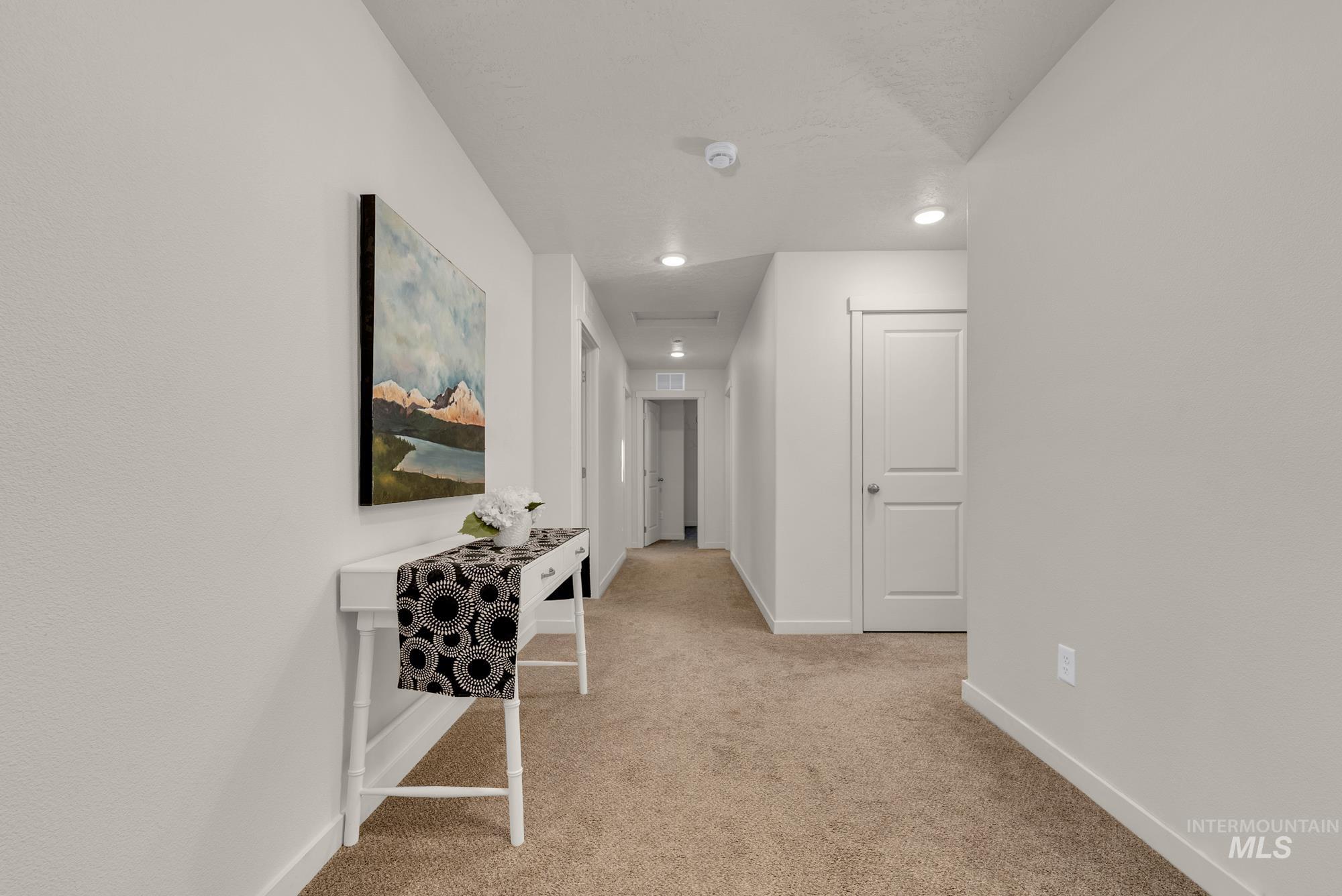 Corridor featuring light colored carpet and recessed lighting