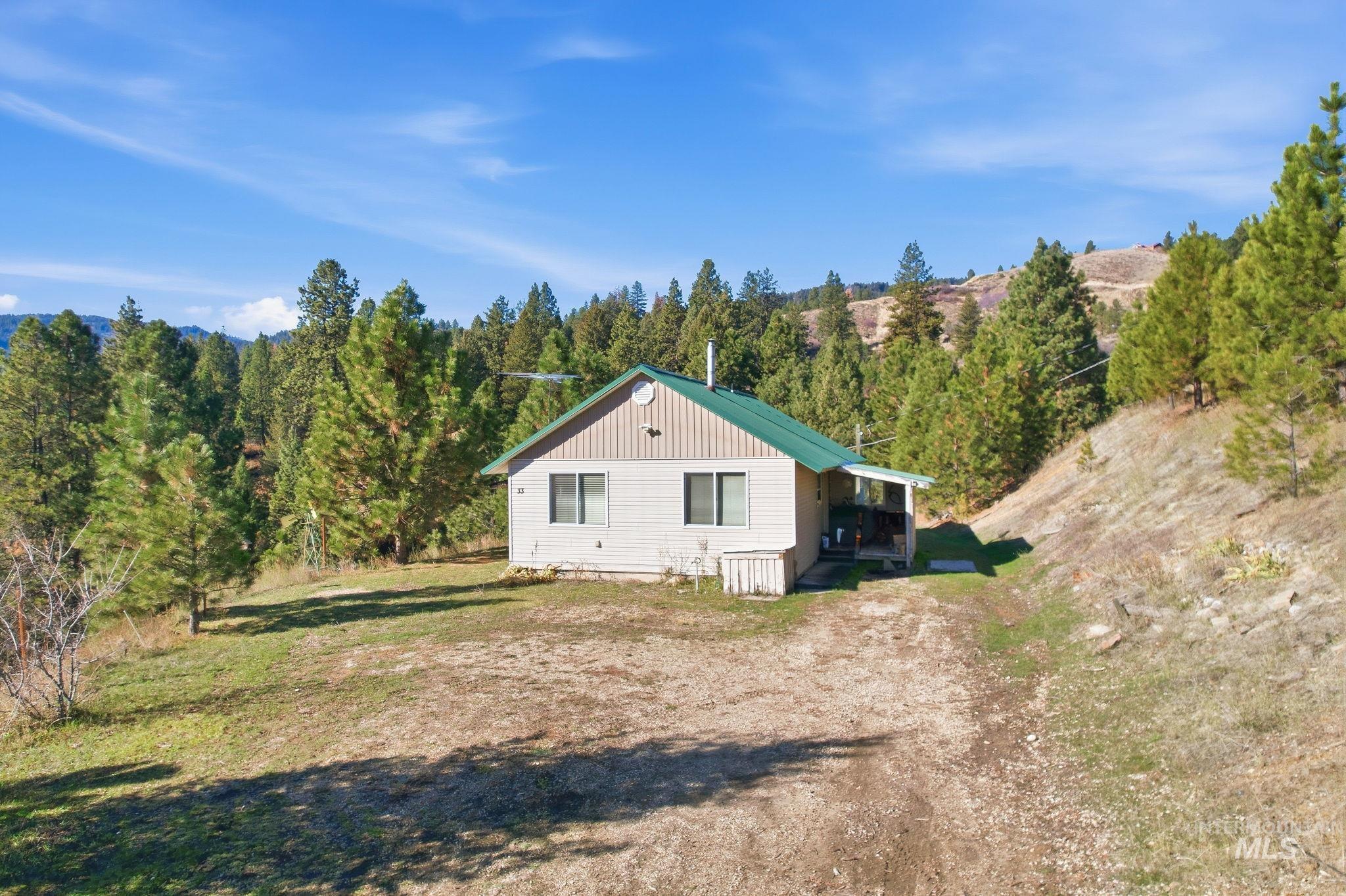 View of side of home with a lawn and a metal roof