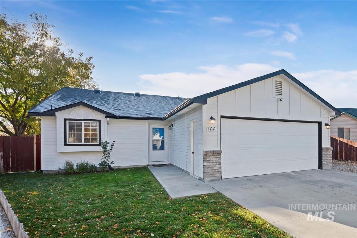 Single story home featuring board and batten siding, driveway, a garage, roof with shingles, and brick siding