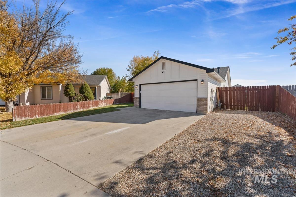 View of home's exterior with brick siding, board and batten siding, a garage, and concrete driveway