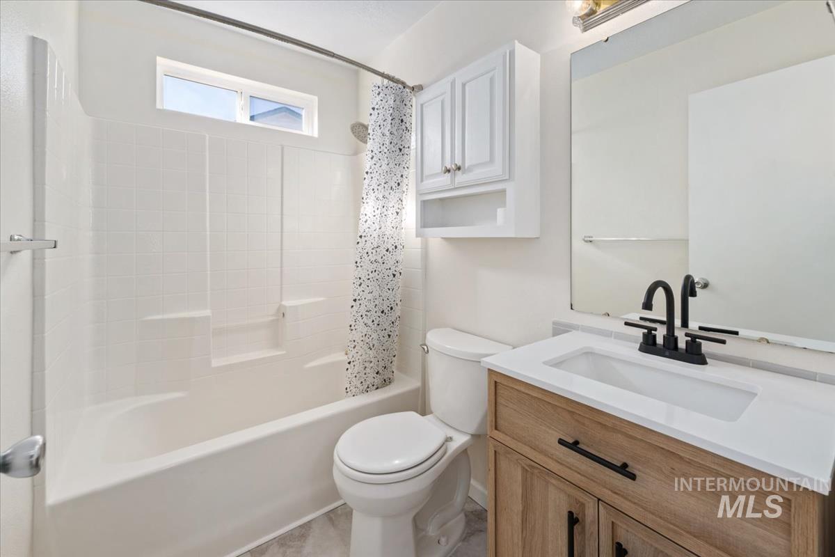Full bath featuring vanity and shower / bath combo