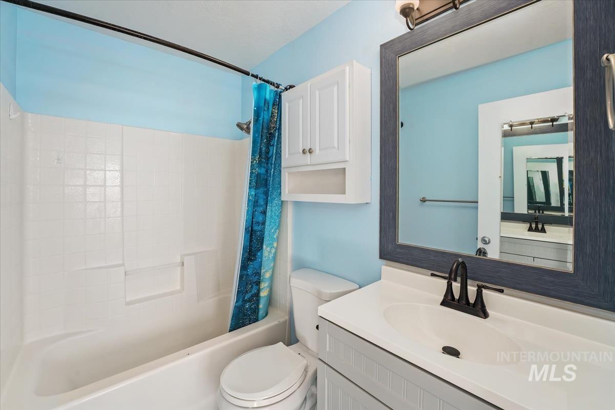 Full bath featuring shower / tub combo with curtain and vanity