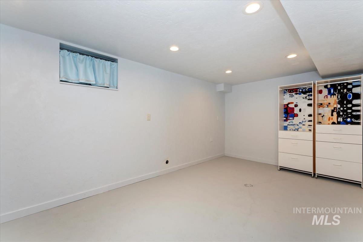 Unfurnished room with finished concrete floors and recessed lighting