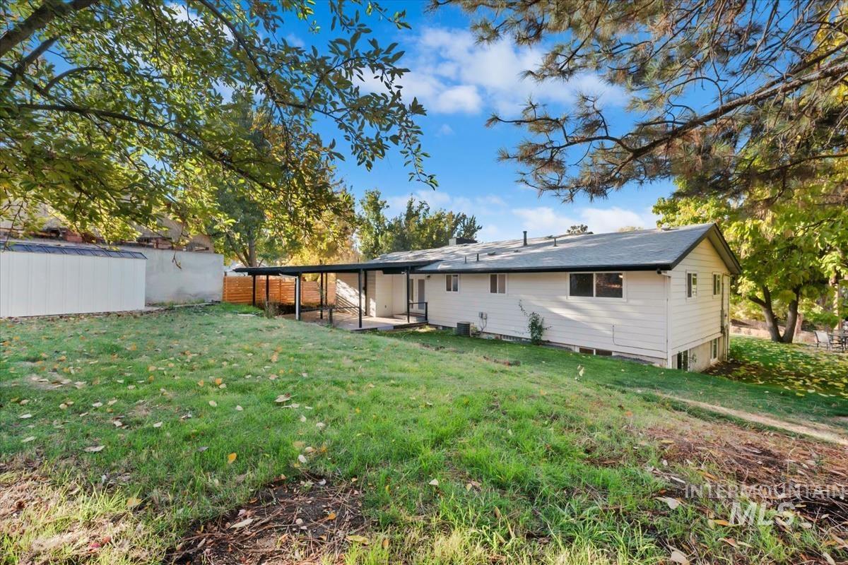 Rear view of house with a yard and a patio area