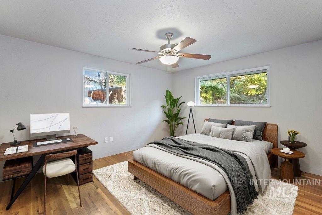 Bedroom with wood finished floors, ceiling fan, a textured ceiling, and a desk