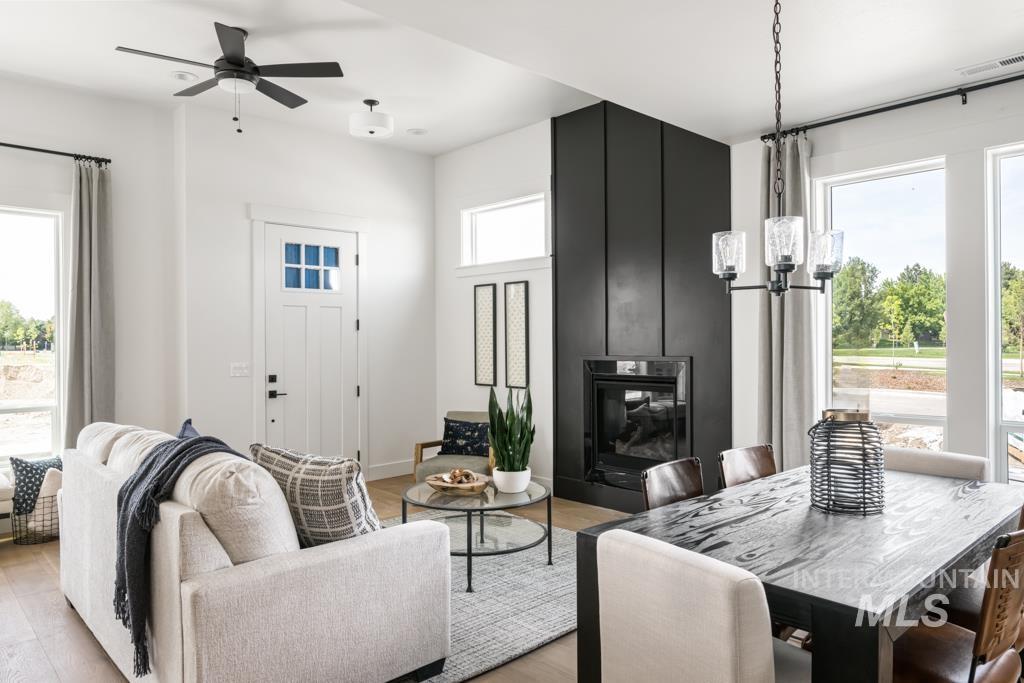 Living area featuring light wood-style floors, a ceiling fan, and a chandelier