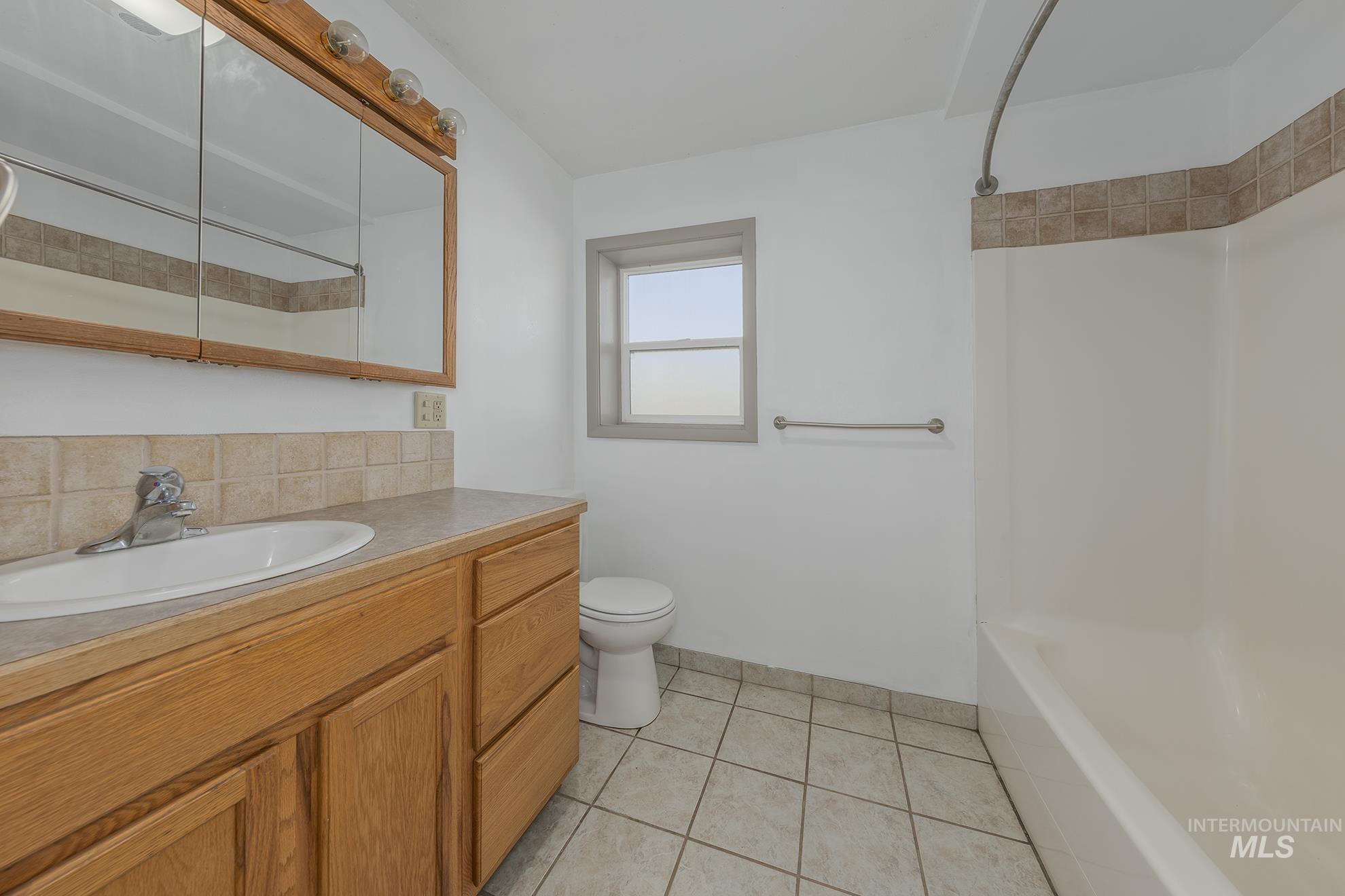 Full bath with vanity, shower / tub combination, and light tile patterned flooring