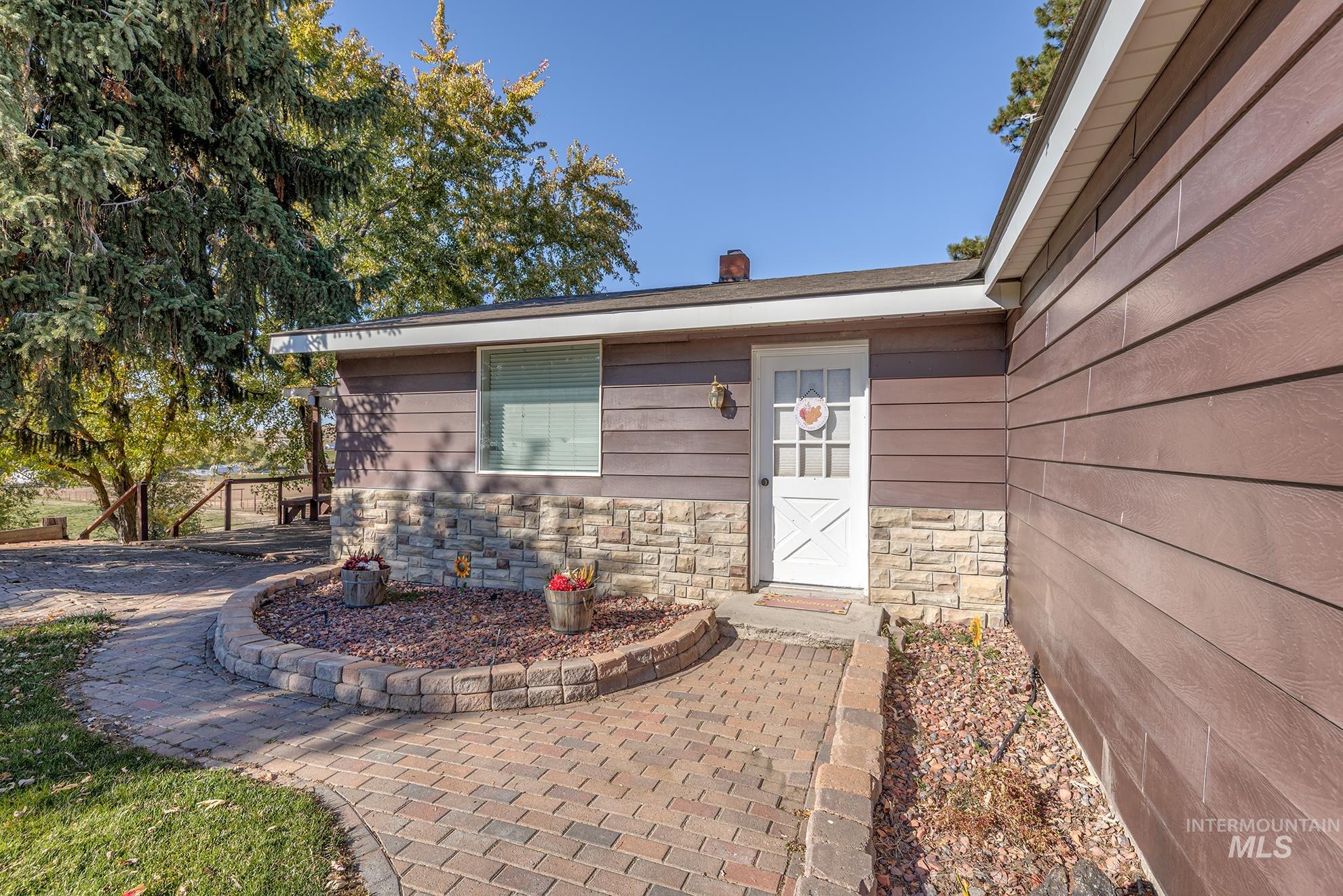 Doorway to property featuring stone siding and a chimney