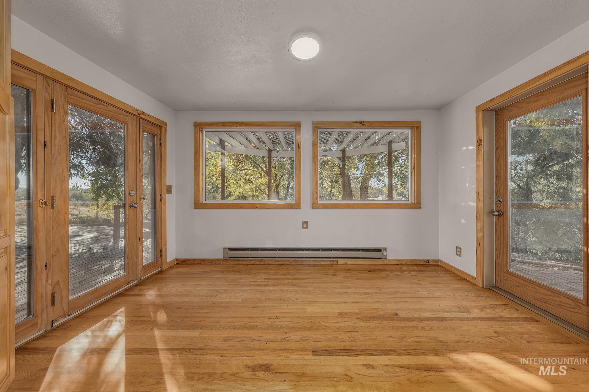 Unfurnished sunroom with baseboard heating