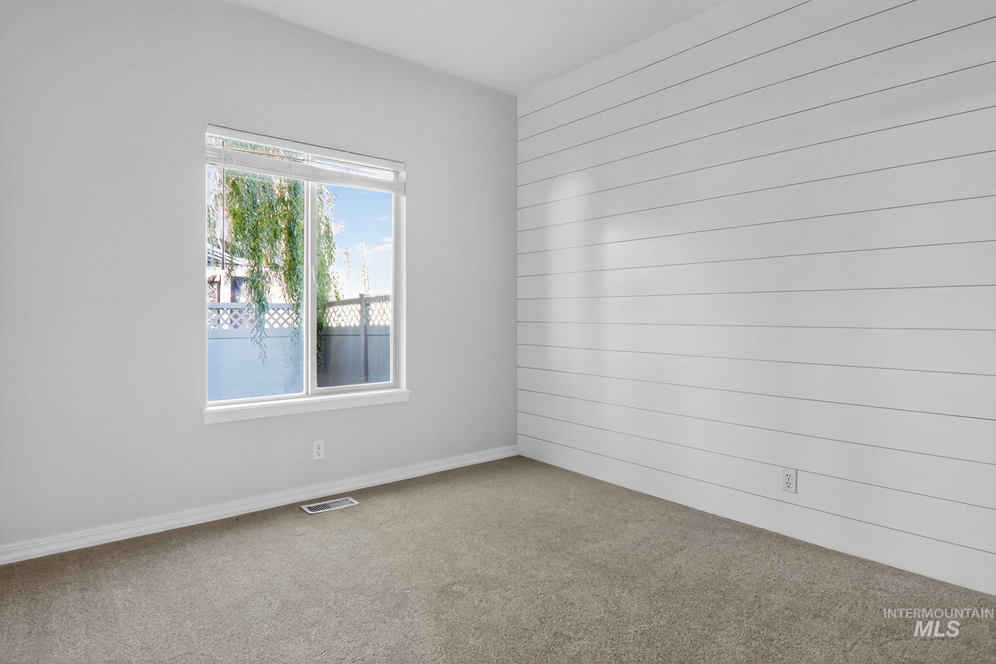 Carpeted empty room with baseboards