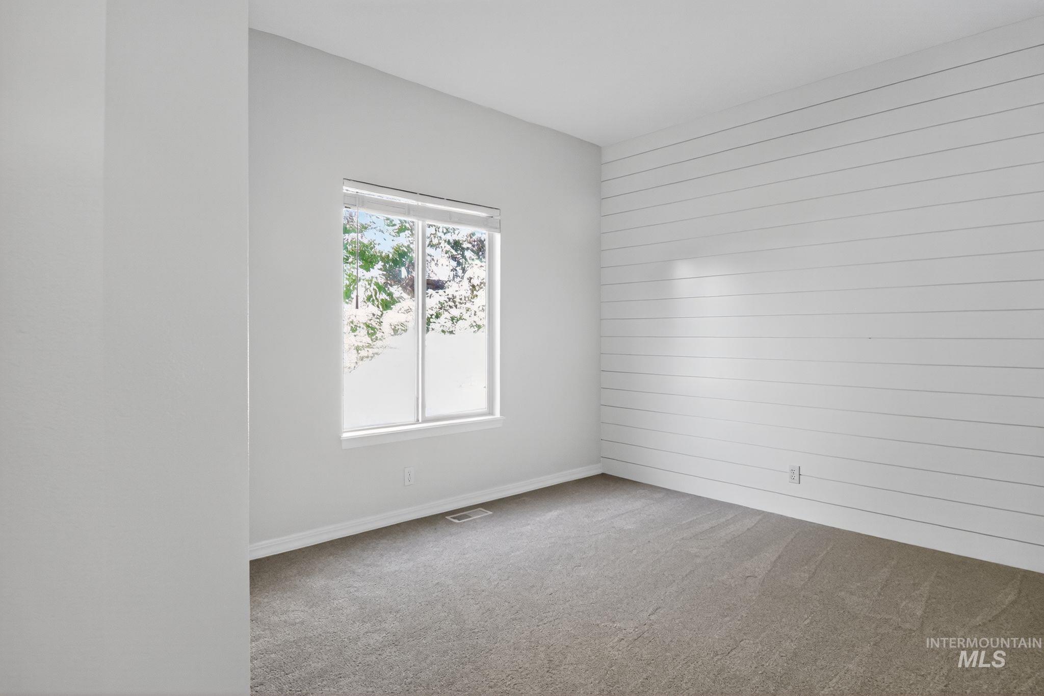 Empty room with carpet and wooden walls