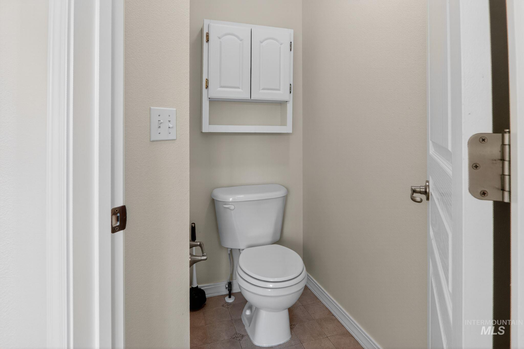Bathroom with toilet and light tile patterned floors