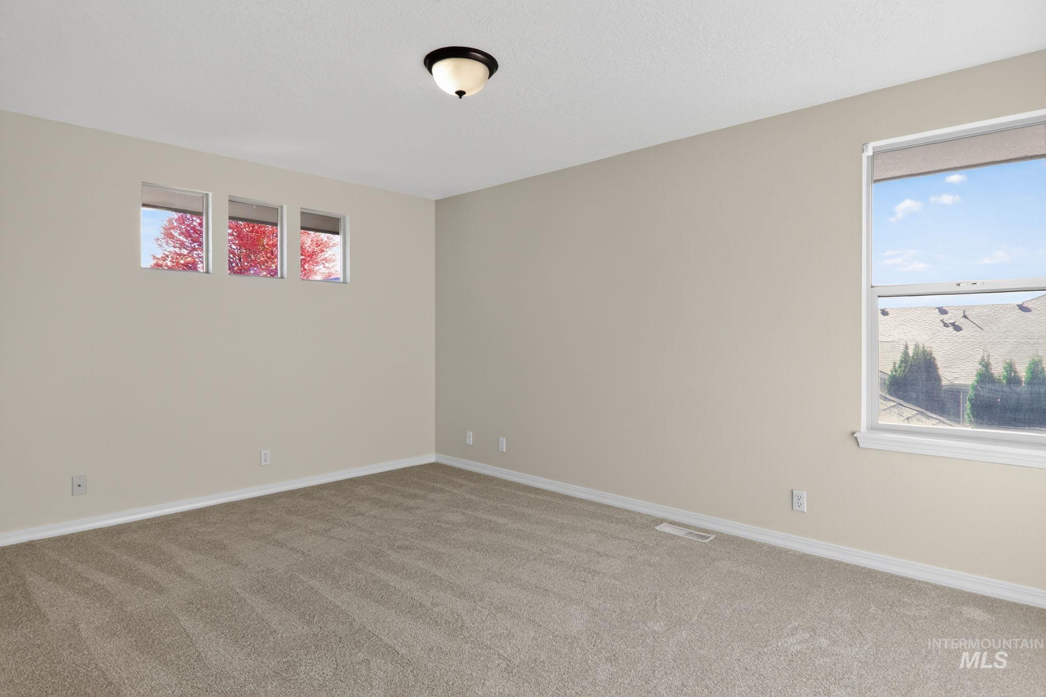 Unfurnished room with light colored carpet and baseboards