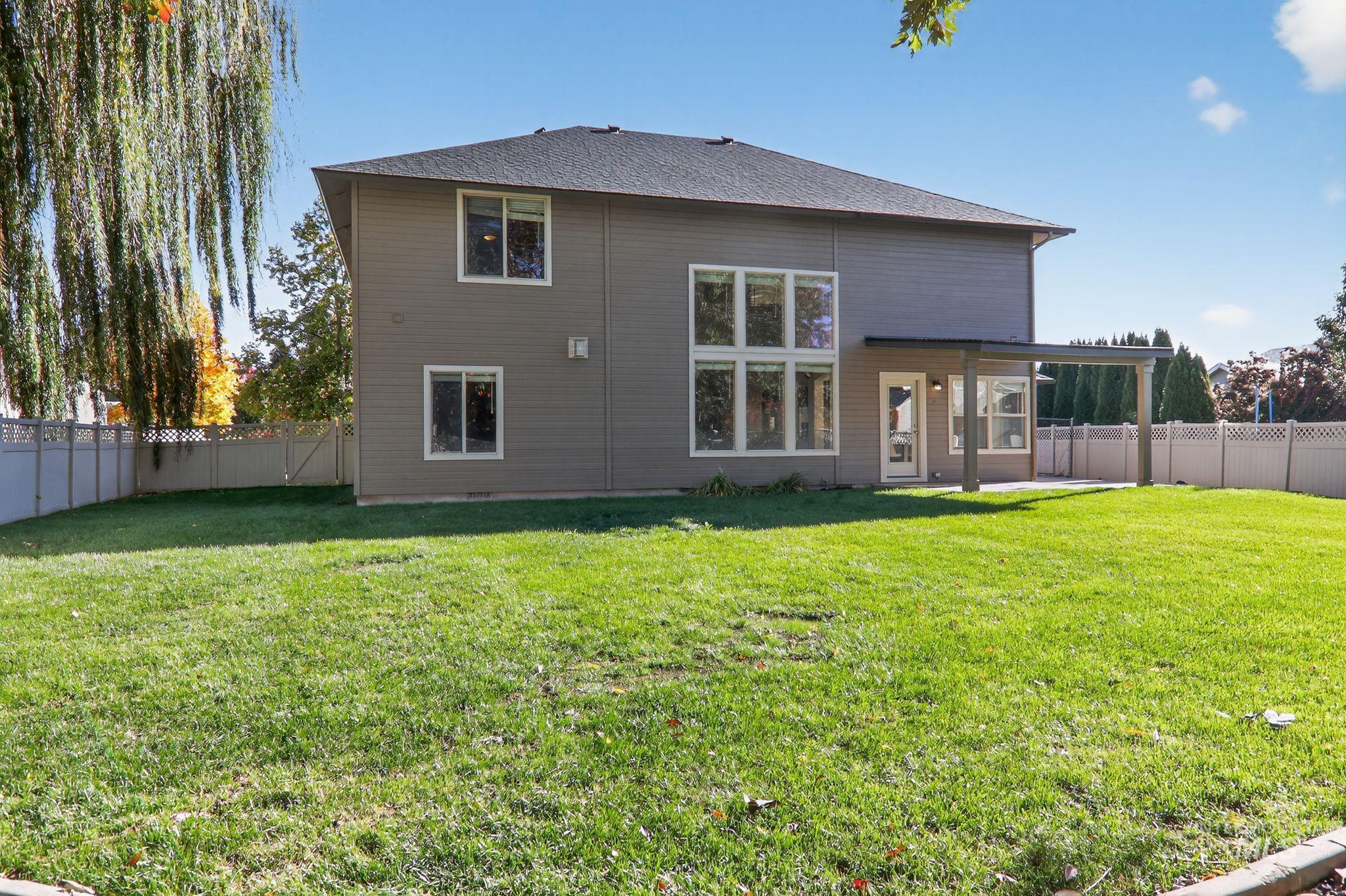 Back of property featuring a fenced backyard, a patio area, and roof with shingles