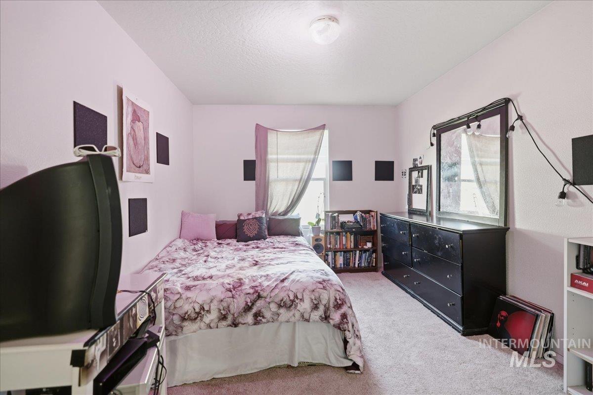 Bedroom with light carpet and a textured ceiling