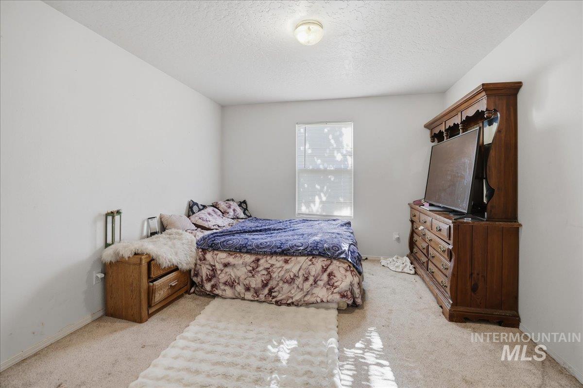 Carpeted bedroom with a textured ceiling